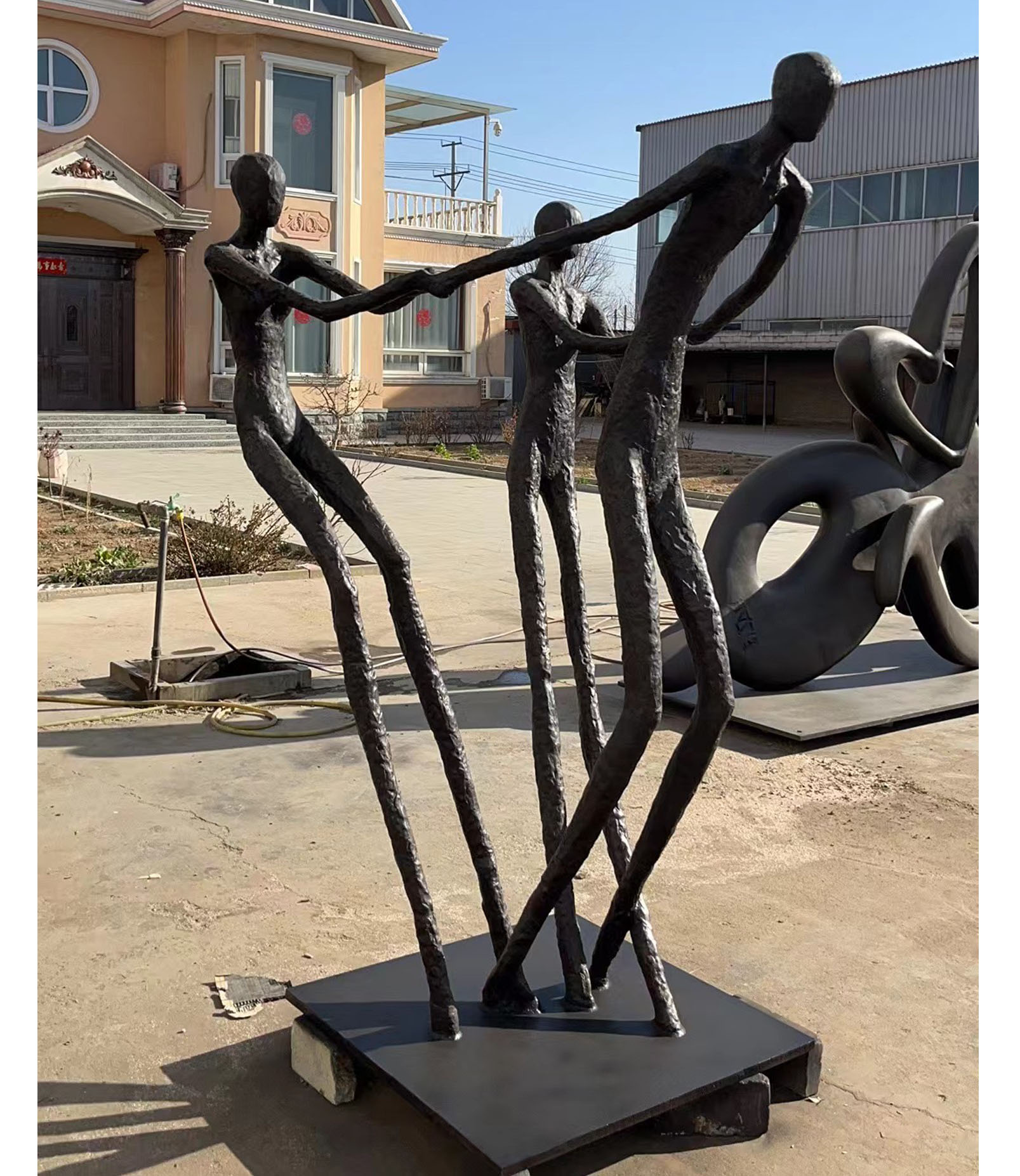 Abstract sculpture of three people working together